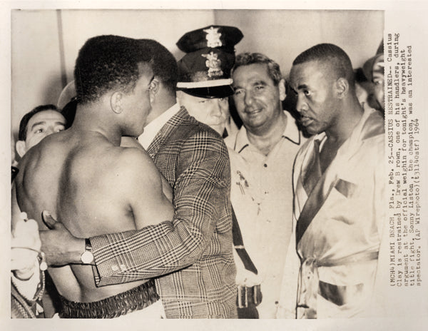 CLAY, CASSIUS-SONNY LISTON I WIRE PHOTO (1964-WEIGH IN)