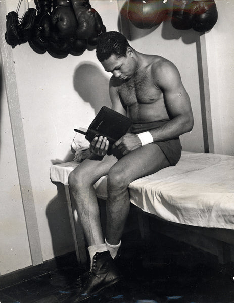 MOORE, ARCHIE WIRE PHOTO (1944-READING THE BIBLE DURING TRAINING)